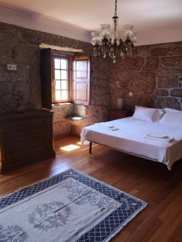 a bedroom with a bed and a chandelier at Casa da Anta Grande in Celorico de Basto