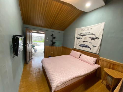 Un dormitorio con una cama con almohadas rosas. en 比西里岸家屋b&b, en Chenggong