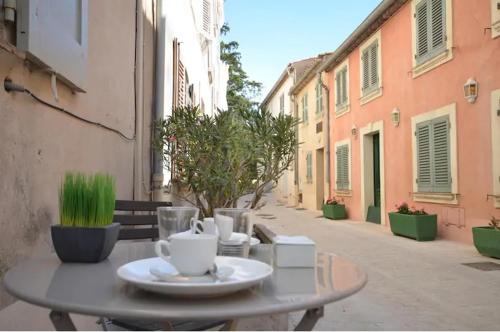 a table with a cup of coffee on a street at Appartement 3 Studios centre ville Saint Tropez avec parking in Saint-Tropez
