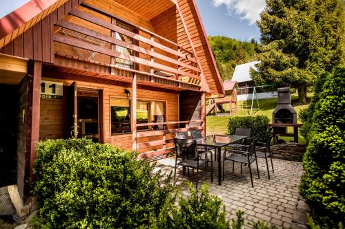 a patio with a table and chairs in front of a house at DOMKI RODIS in Baligród