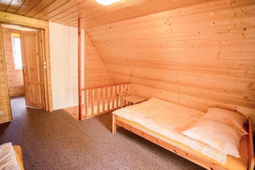 a room with a bed in a wooden cabin at DOMKI RODIS in Baligród