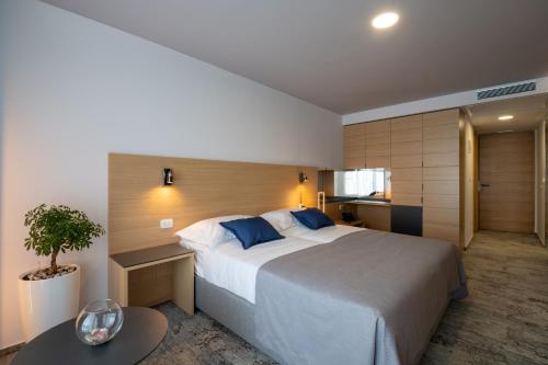 a bedroom with a large bed and a table at Hotel VAPORE in Neum