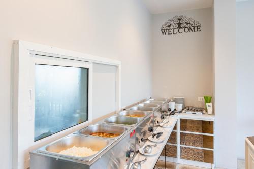 een keuken met een rij dienbladen vol eten bij Siam Tharadol in Bangkok