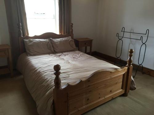 a bedroom with a wooden bed and a window at The Old Rose And Crown - St Neots in Saint Neots