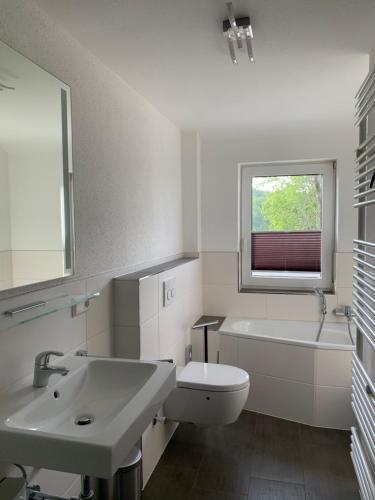 a bathroom with a sink and a tub and a toilet at Harzstübl25 in Sankt Andreasberg