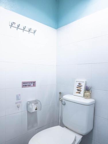 a bathroom with a toilet with a sign on the wall at Chan Cha La 99 Hostel in Bangkok