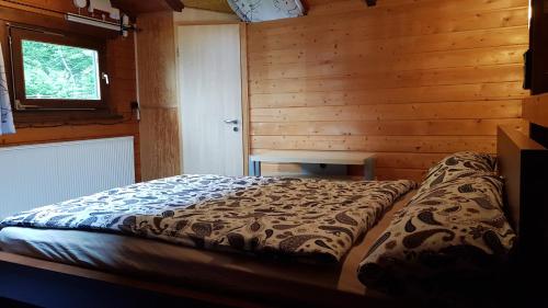 um quarto com uma cama num chalé de madeira em Jagdhaus Malzhagen em Nümbrecht
