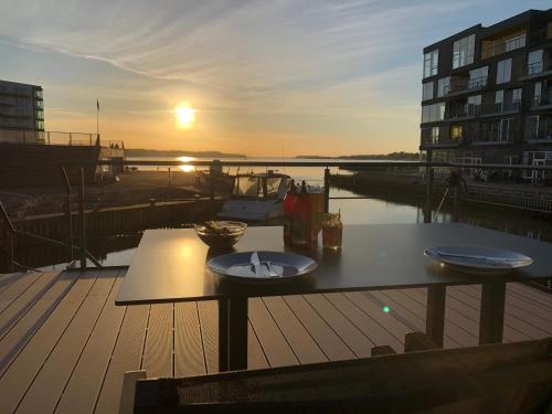 einen Tisch mit einem Teller Essen auf dem Deck in der Unterkunft MarinaVilla in Nykøbing Falster