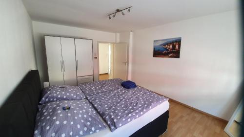a bedroom with a bed with a purple comforter at Ferienwohnung Biewer in Trier