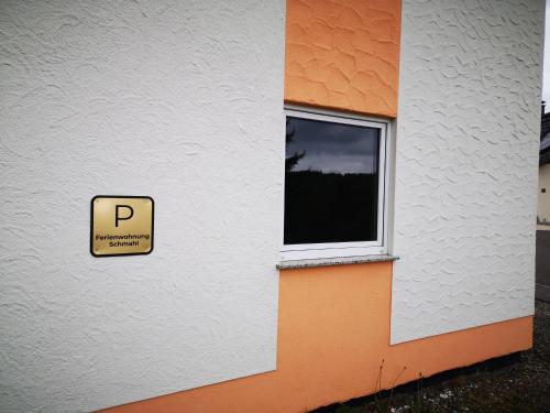 a sign on the side of a building with a window at Ferienwohnung Schmahl in Schleiden