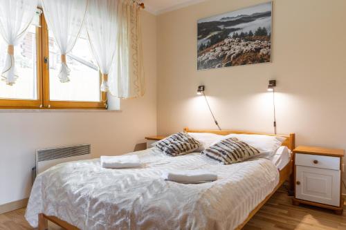 a bedroom with a bed with two pillows on it at Apartamenty Snowbird Zakopane in Kościelisko