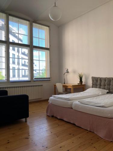 um quarto com 2 camas, uma secretária e janelas em berlincity em Berlim