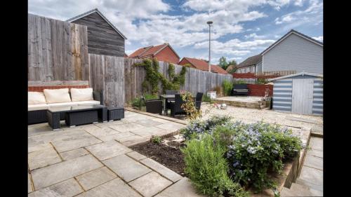 a patio with a couch and a fence at Entire 4 Bed Townhouse in Exeter