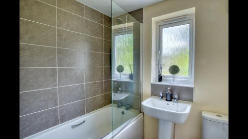 a bathroom with a sink and a toilet and a shower at Entire 4 Bed Townhouse in Exeter
