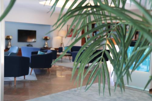 a living room with blue furniture and a plant at OPOHOTEL Porto Aeroporto in Maia