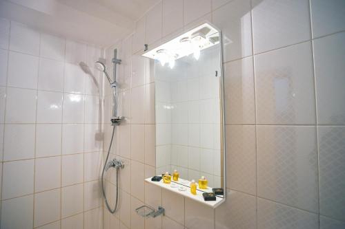 a bathroom with a shower and a mirror at Hotel Victoria in Mamaia