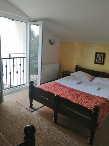 a bedroom with a bed and a large window at Villa Bozovic in Zlatibor