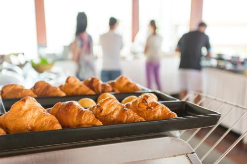 a tray of croissants on a counter in a bakery at Andaman White Beach Resort - SHA Plus in Nai Thon Beach
