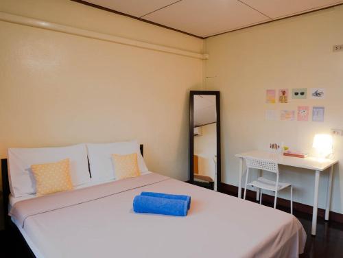 1 dormitorio con cama, escritorio y espejo en Chan Cha La 99 Hostel en Bangkok