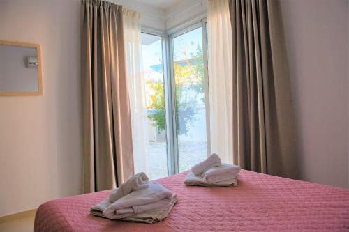 a bedroom with a pink bed with a window at Coral Bay Villa 10 in Coral Bay