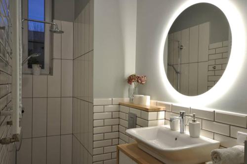 Baño blanco con lavabo y espejo en Poznańska Apartment, en Poznan