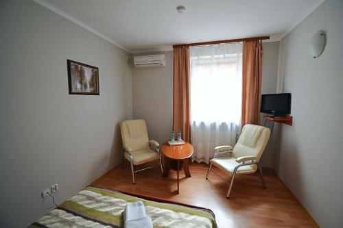 sypialnia z łóżkiem, 2 krzesłami i stołem w obiekcie Hotel Awis w Kutnie
