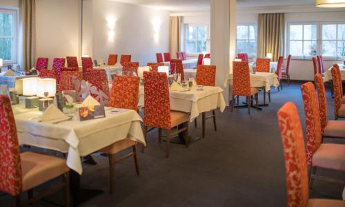 a dining room with tables and chairs and tablesktop at Hotel Am Kurpark Späth in Bad Windsheim