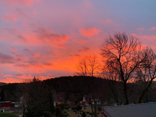 a sunset over a town with trees and a mountain at Harzstübl25 in Sankt Andreasberg
