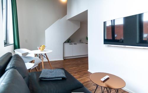 a living room with a couch and a table at Soulfactory Apartments in Neu Ulm