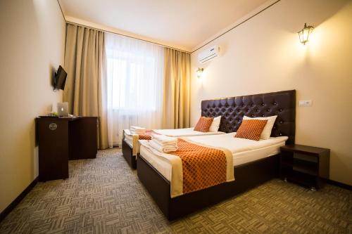 um quarto de hotel com duas camas e uma janela em Grand Hotel em Ulyanovsk