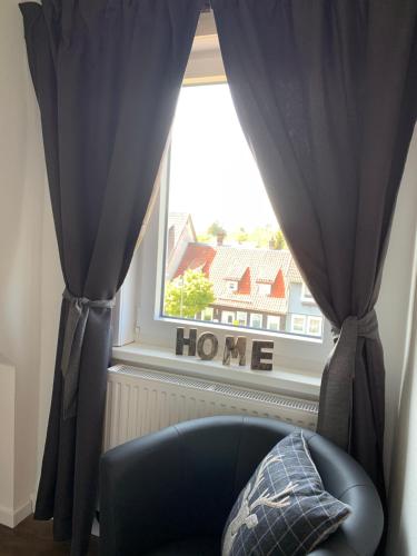 a blue chair in front of a window with a house at Harzstübl25 in Sankt Andreasberg