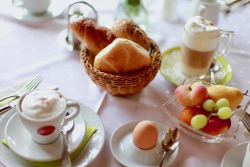 a table topped with plates of food and cups of coffee at Hotel-Restaurant am Hochfuchs in Eugendorf