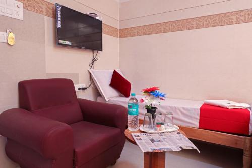 a living room with a chair and a bed at Laila Palace in Salem