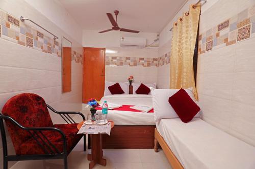 a bedroom with two beds and a chair and a table at Laila Palace in Salem