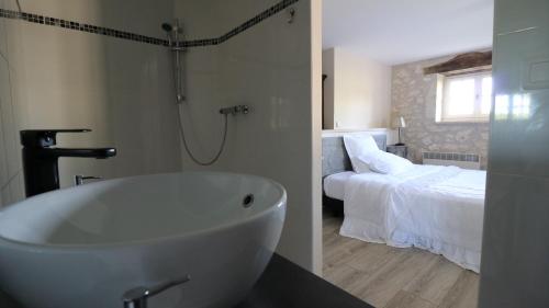 Montaigu-de-QuercyにあるChambre d'hotes la Quercynoiseのバスルーム(バスタブ付)、ベッドルーム(ベッド付)が備わります。