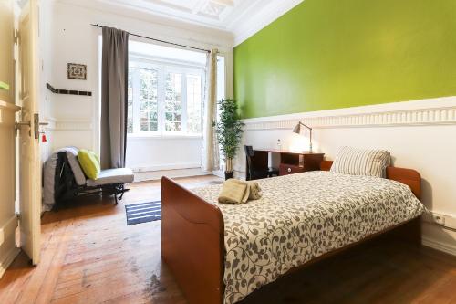 - une chambre avec un lit et un mur vert dans l'établissement Lisbon Garden Flower, à Lisbonne