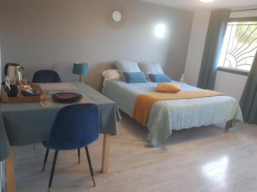 a bedroom with two beds and a table and a table and chairs at Chatimbarbe in Yssingeaux