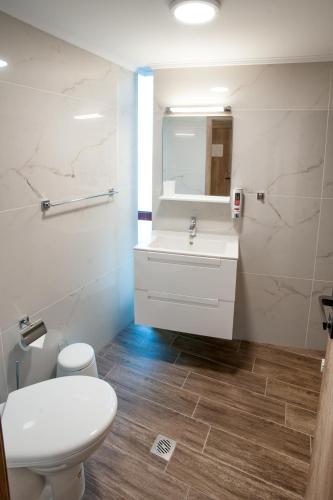 a bathroom with a white toilet and a sink at White House Family Hotel Spa zone in Balchik