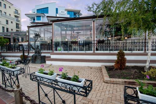 a patio with two benches and flowers in front of a building at White House Family Hotel Spa zone in Balchik