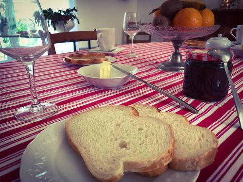 una mesa con un plato blanco con pan. en Les Chambres d'hôtes du Faubourg en Saint-Riquier