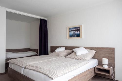 a bedroom with a large bed with white walls at Haus Rungholt in Nordstrand