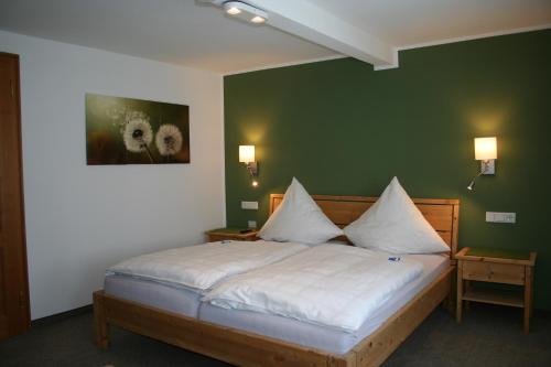 a bedroom with a bed with a green wall at Landhaus Gnacke in Schmallenberg