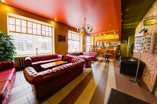 a restaurant with red leather couches and a bar at Viktorija in Rīga