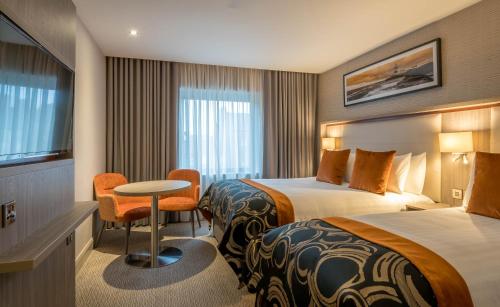 Cette chambre comprend 2 lits et une table. dans l'établissement Clayton Whites Hotel, à Wexford