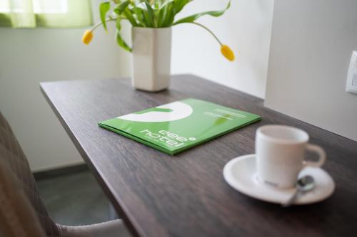 a table with a green book and a cup of coffee at eee Hotel Liezen in Liezen