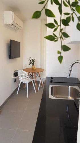 una cocina con un fregadero y una mesa en The Blue House, en Jerusalén