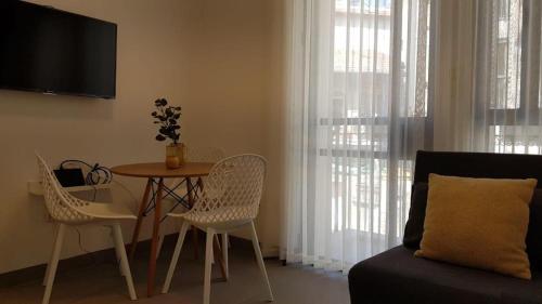 ein Wohnzimmer mit einem Tisch, Stühlen und einem Sofa in der Unterkunft The Blue House in Jerusalem
