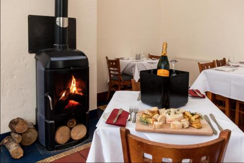 a table with a fireplace and a plate of food at 12 Borwick Lakes by Waterside Holiday Lodges in Carnforth
