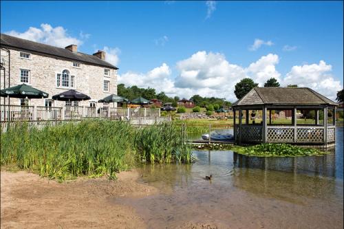 a gazebo in the water next to a building at 12 Borwick Lakes- Newly Refurbished in Carnforth