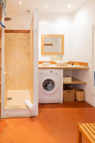 une salle de bain avec une machine à laver et un lavabo dans l'établissement Logement atypique dans la rue Fourmillière, à Antibes
